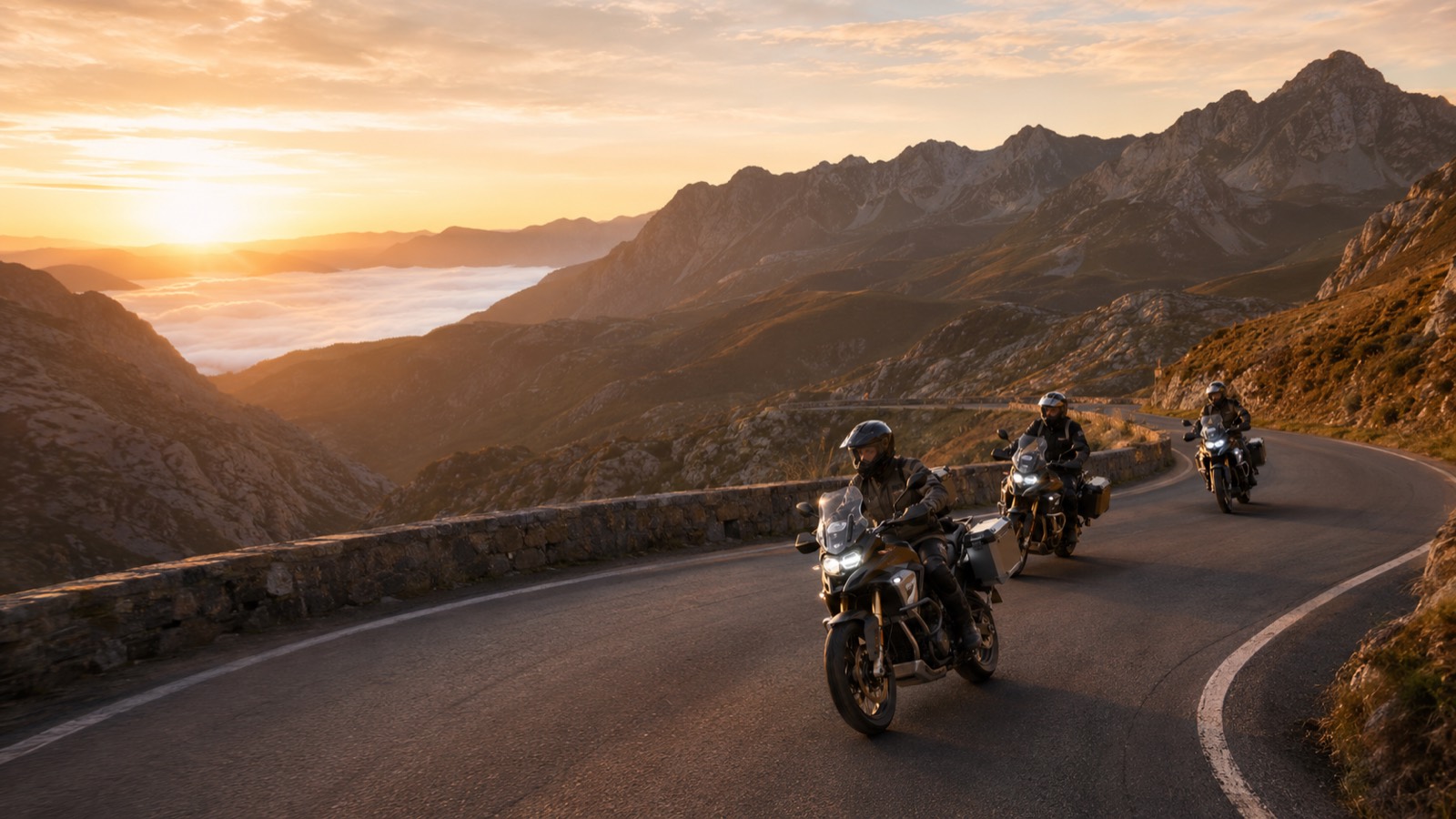 Motorcyclists riding a winding mountain road at sunrise.